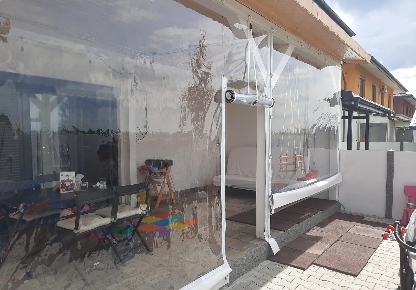Terasă închisă cu folie cristal transparentă prinsă cu capse și bride