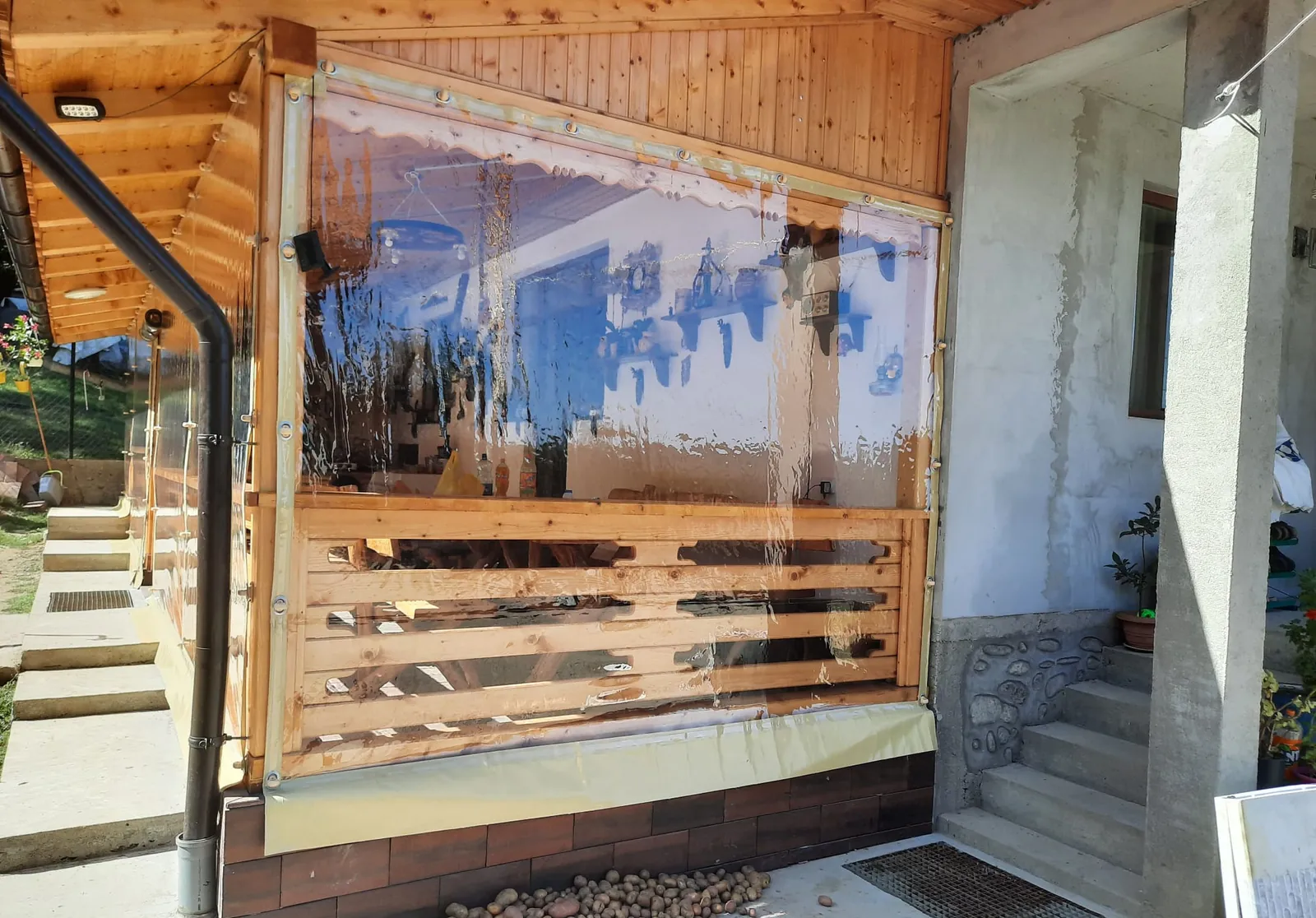 Terasă închisă cu folie cristal transparentă prinsă cu capse și bride