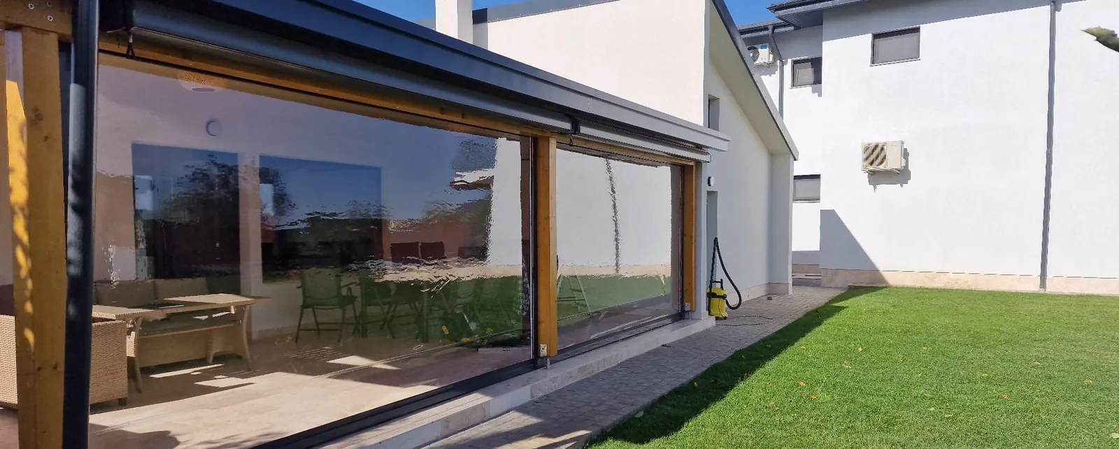 Terasă închisă cu folie cristal transparentă pe rulou casetat
